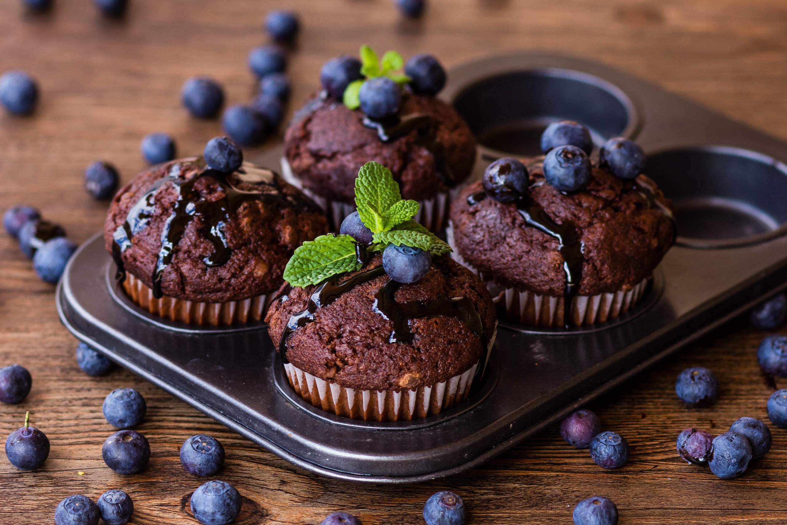 Chocolate,Muffins,With,Chocolate,Syrup,,Blueberries,And,Mint,In,A