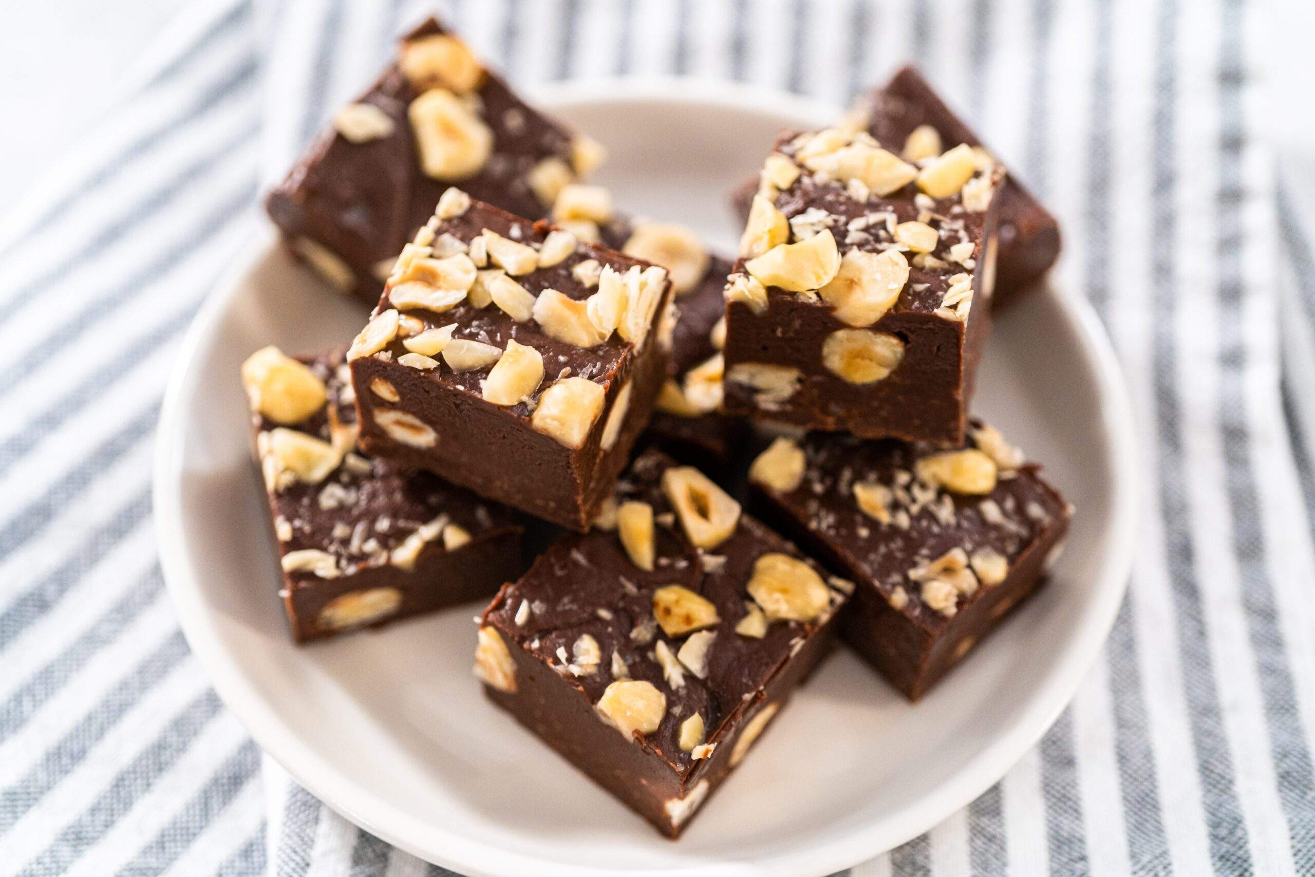 Homemade,Chocolate,Hazelnut,Fudge,Square,Pieces,On,A,White,Plate.