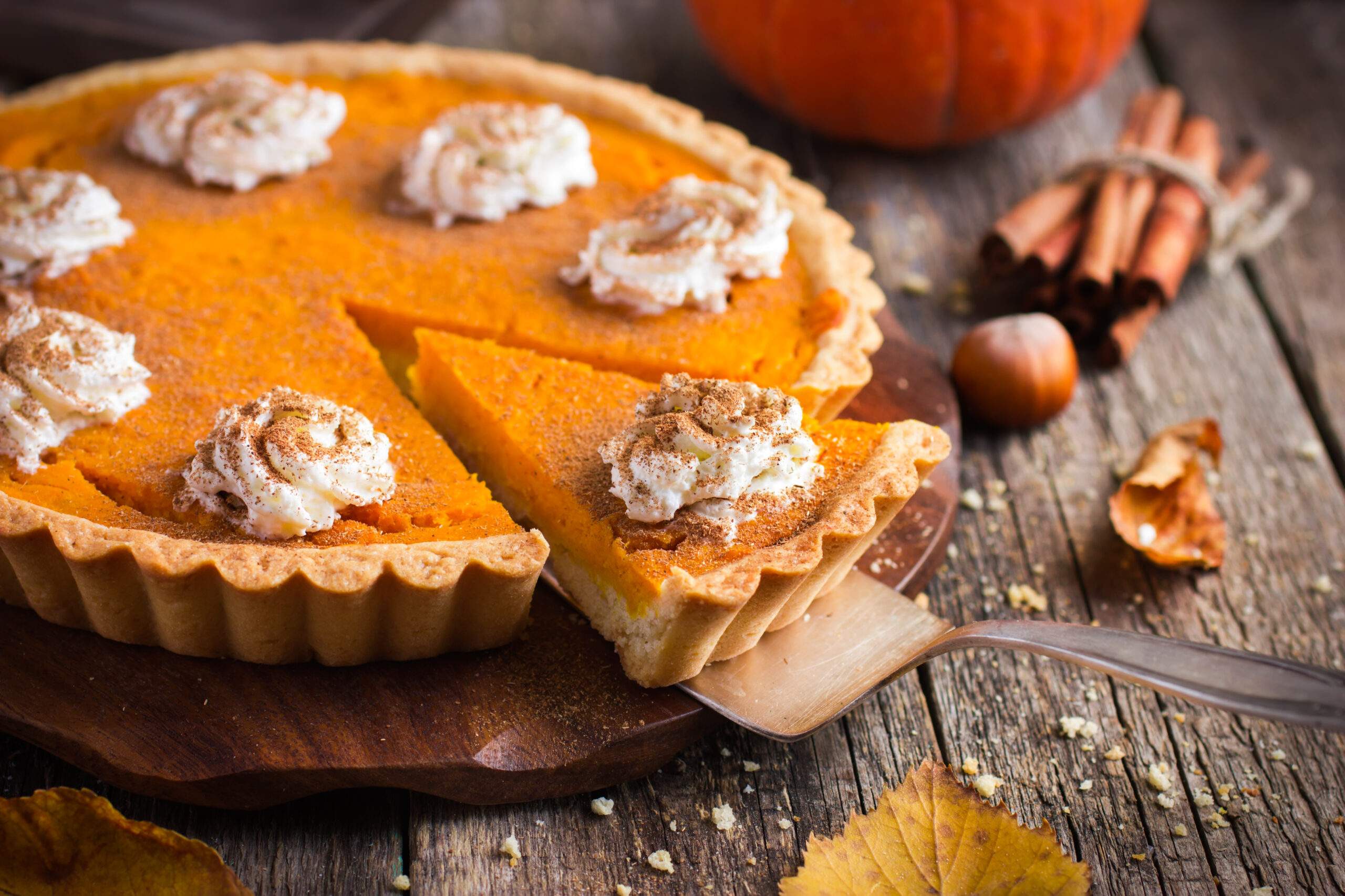 Pumpkin,Pie,With,Whipped,Cream,And,Cinnamon,On,Rustic,Background,